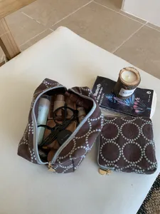 Close-up detail of the retro embroidered canvas makeup pouch and matching coin purse set.