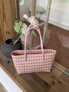 Detailansicht des rosa und braunen geflochtenen Kunststoff-Einkaufskorbs, lässiges Design.