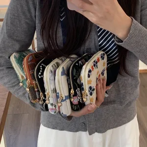 Geborduurd linnen sieradentasje met rits, vintage bloemige opbergtas voor ringen en oorbellen.