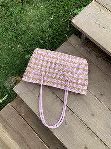 Nahaufnahme der rosa beige gewebten Strandtasche, zeigt feine Textur fur den sommerlichen Alltag.