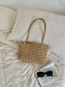 Beige woven shoulder tote bag detail in bedroom scene, stylish casual daily summer accessory.