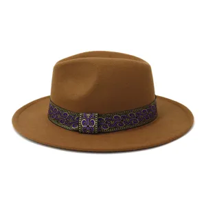 Vista detallada del sombrero fedora de fieltro marrón con banda estampada en color morado.