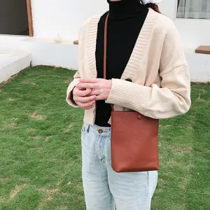 Braune PU Leder Umhängetasche Detail, stilvolle vertikale Beuteltasche im Freien getragen.