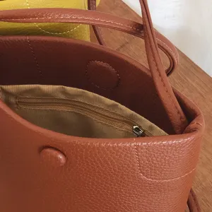 Braune PU Leder Umhängetasche mit innerer Reißverschlusstasche und Druckknopf.