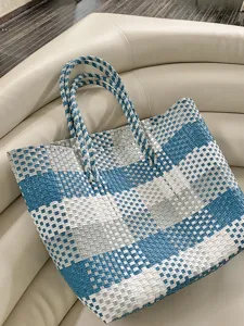 Gedetailleerde close-up van een blauw-witte geweven tas op bank, ideale zomerse stijl.