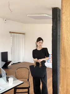 Dettaglio della borsa shopper nera intrecciata con manici in bambù e corda di cotone.
