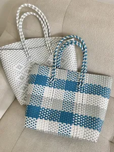 Gedetailleerd overzicht van geweven totebags, grote mandstijl schoudertas voor de zomer.