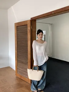 Borsa tote in paglia intrecciata con manici in bambù, ideale per l'estate e l'uso quotidiano.