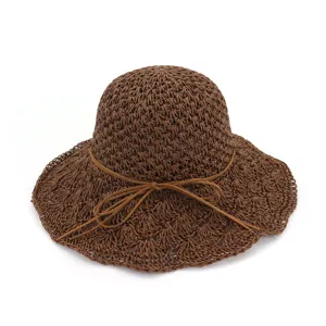 Detailed view of the brown crochet straw hat showing delicate woven texture and bow tie.