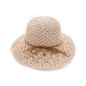 Close-up detail of the beige crochet straw hat featuring a wide hollow brim and a chic brown bow.