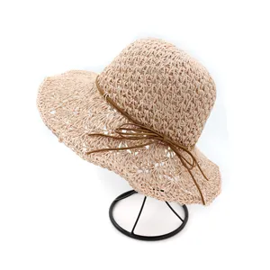 Detailed view of women summer crochet straw sun hat with cute brown bow ribbon.