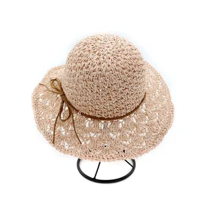 Detailed view of women's handmade crochet straw sun hat, hollow-out wide brim, chic bow tie.