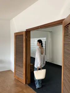 Vista dettagliata di una borsa tote in cotone intrecciato a mano con manici in bambù.