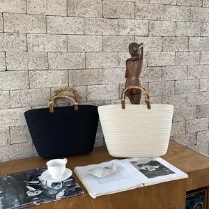 Grande borsa tote intrecciata in corda di cotone con manici in bambù, elegante.