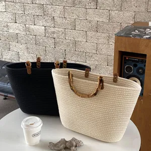 Vista dettagliata della borsa tote in corda di cotone intrecciato con dettagli in bambù.