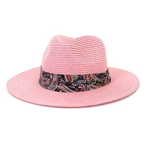 Pink straw fedora sun hat for summer outdoor travel, features a stylish colorful paisley band.