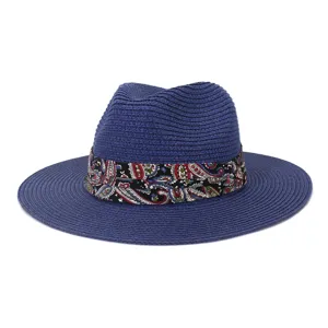 Blue fedora straw hat detail view showing the colorful paisley ribbon band and fine woven texture.