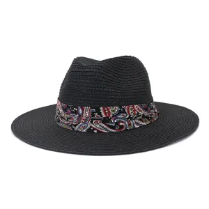 Detailed shot of a black straw fedora hat featuring a colorful paisley pattern ribbon band.