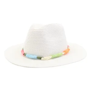 Close-up detail of a white straw fedora hat featuring a colorful woven band for summer sun.