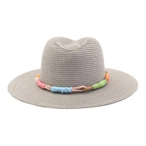 Detail view of the grey fedora straw hat featuring a vibrant colorful braided rope accent.
