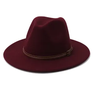 Burgundy felt fedora hat detail featuring thin brown leather belt and buckle on flat brim.