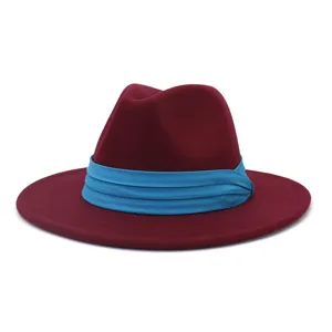 Vista ravvicinata del cappello fedora rosso vino con tesa piatta e nastro plissettato turchese.