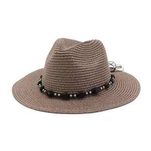 Detail opname van de 7 cm brede strooien zonnehoed met zwarte kralenband voor zomerstrand.