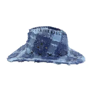 Detailed view of the distressed denim western cowboy hat with frayed patchwork and wide brim.