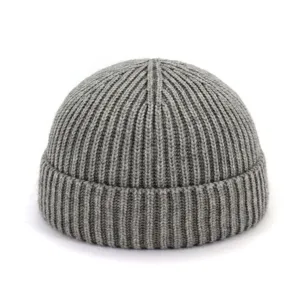 Gros plan détail du bonnet docker en tricot côtelé gris, texture fine style chaud automne hiver.