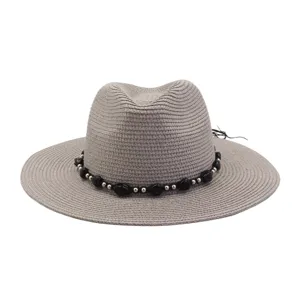Zomerse strohoed met brede rand en kralenband, ideaal voor strand en zonbescherming.
