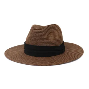 Detail view of brown straw fedora hat with black ribbon band, summer sun protection.