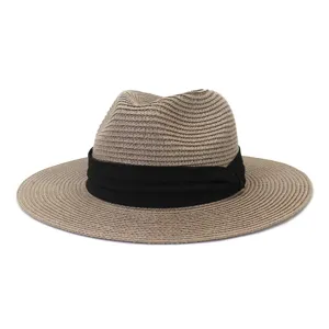 Details of the woven straw hat with black ribbon, classic summer sun protection design.