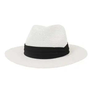 Detail shot of white straw fedora hat featuring black band for summer beach sun protection.