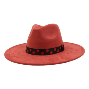 Gros plan détaillé sur le chapeau fedora en suédine rouge avec un ruban noir à pois rouges.