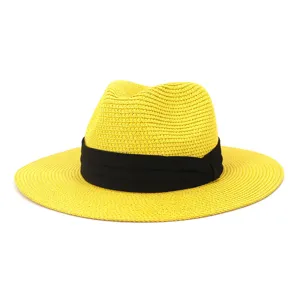 Detailed view of yellow straw fedora hat with black ribbon for summer beach sun protection.