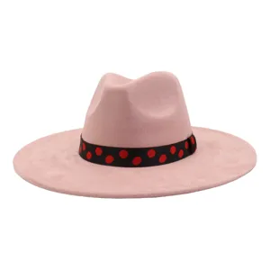 Détail de chapeau fedora plat en suédine rose, chapeau élégant avec bande à pois noirs.