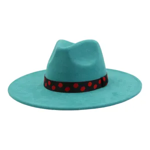 Gros plan sur le chapeau fedora en suédine turquoise avec son ruban à pois rouges et noirs.