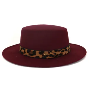 Details van bordeauxrode wollen platte hoed met stijlvolle luipaardband en metalen stud.