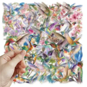 Close up of transparent PET watercolor hummingbird sticker held by hand with sticker background.
