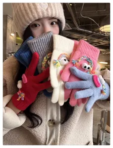 Cute quirky knitted gloves with googly eyes and rainbow braids, warm winter thermal gear.