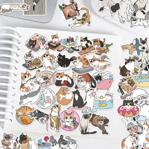Close-up detail shot of cute cartoon cat stickers displayed on a white notebook page.