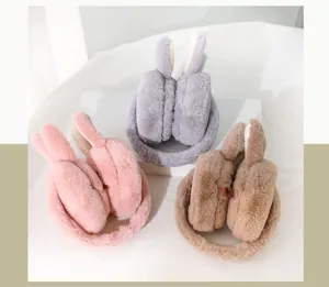 Detailopname van pluche winteroorwarmers met schattige konijnenoren in drie zachte kleuren.