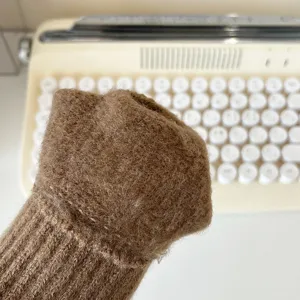 Winter knit warm gloves detail view, soft woolen material, stylish brown color for cold weather use.