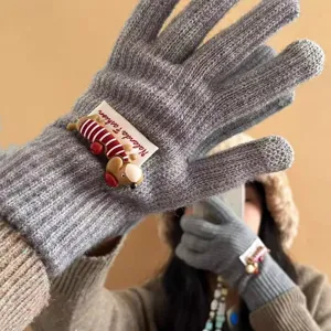Nahaufnahme kuscheliger grauer Winter-Strickhandschuhe mit süßem Cartoon-Welpen und Plüsch.