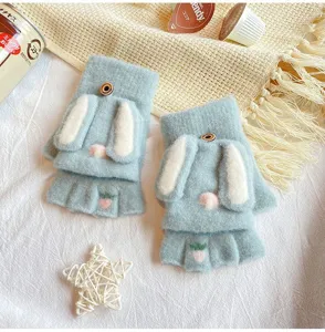Close-up detail of cute knitted flip-top fingerless gloves with rabbit ears and carrot embroidery.