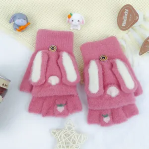 Close-up detail of cute pink knitted fingerless gloves with white rabbit ears and soft texture.
