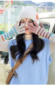 Detailed shot of striped knitted warm gloves worn outdoors, stylish fingerless design.