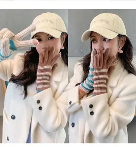Close-up detail of women's long knit striped fingerless gloves, winter warm and cozy fashion.