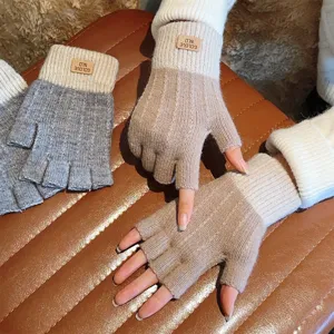 Close-up detail shot of winter knitted fingerless gloves with warm fleece lining and leather label.