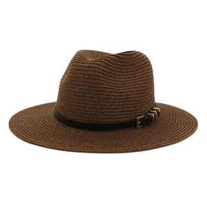 Detailed close-up of brown straw fedora hat with black belt and metal buckle decoration.